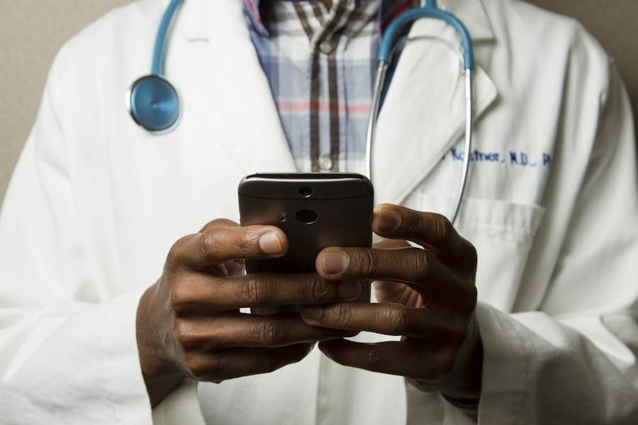 Médico com telefone nas mãos